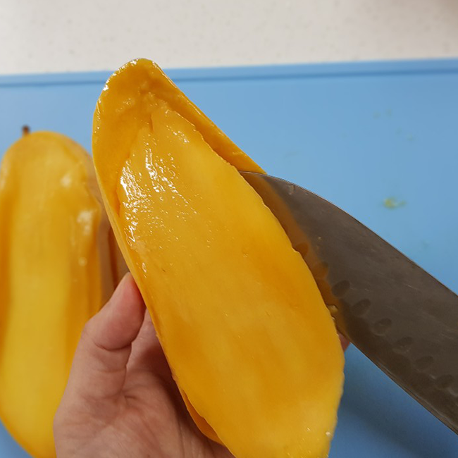 種のないマンゴーの実を切りぬきます。