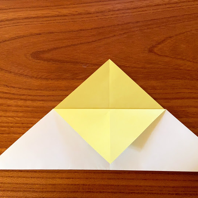 三角の頂点を１枚だけ、真ん中の線に合わせて下まで折ります。